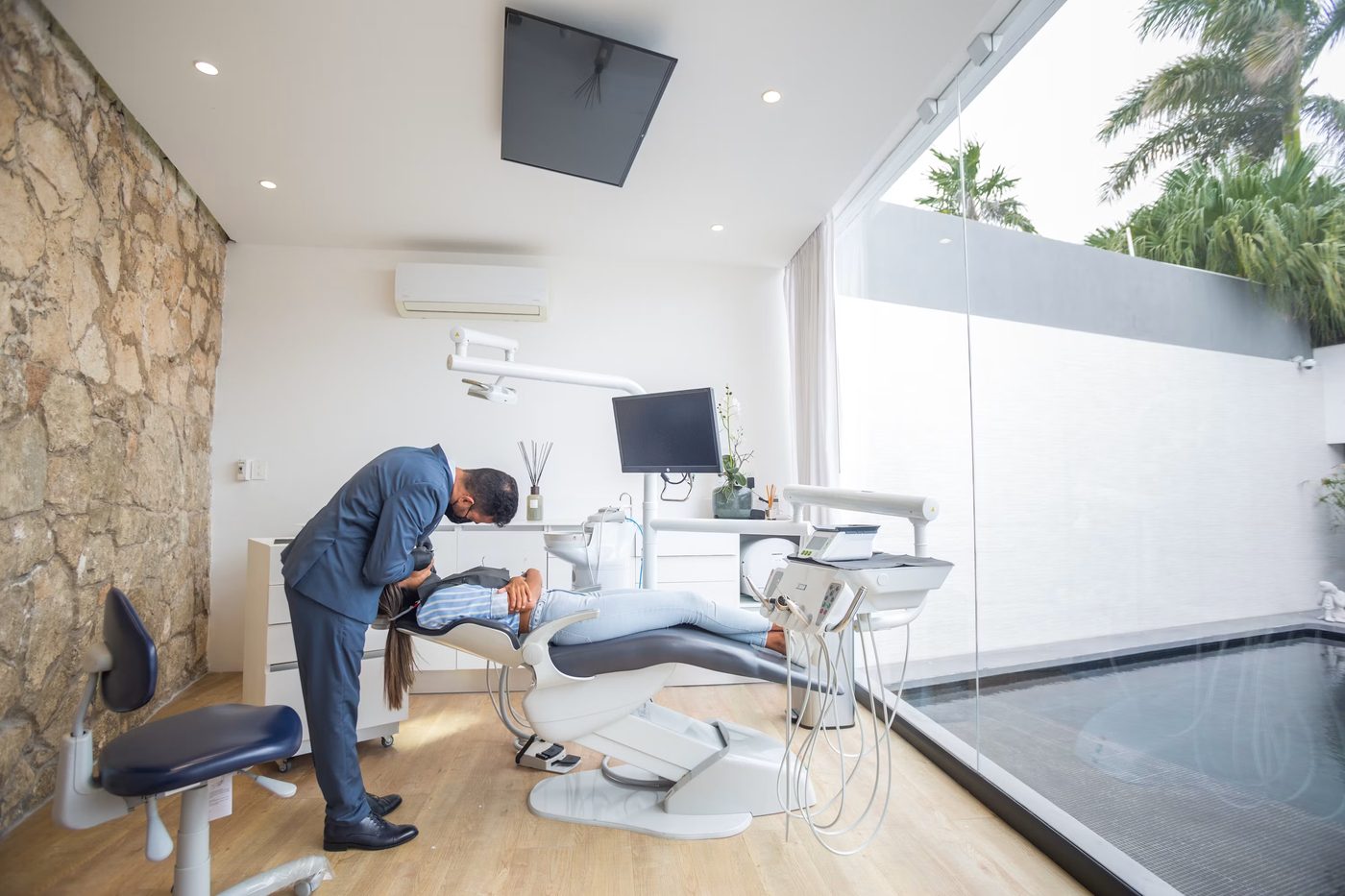 A dentist gently treating a patient in a bright, modern treatment room
